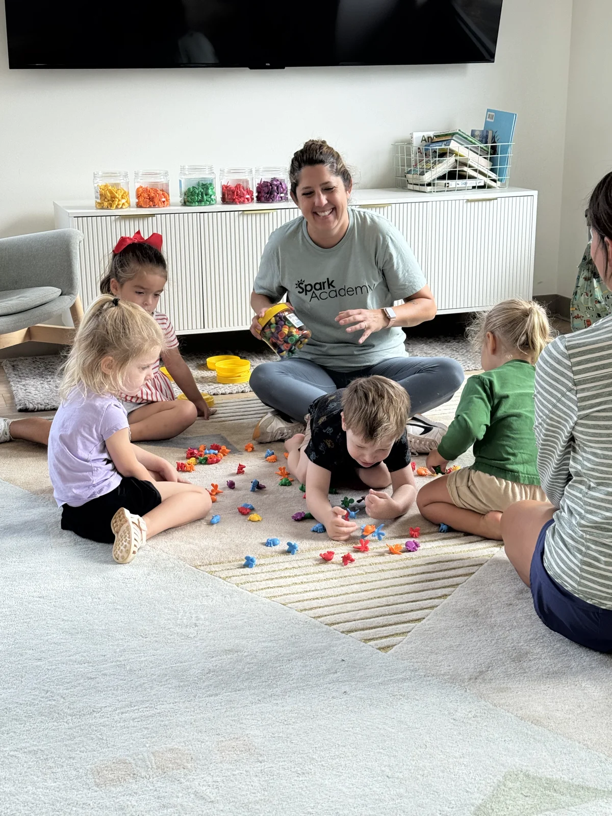 Dr. Peterson on the floor playing and learning with students at Spark Academy
