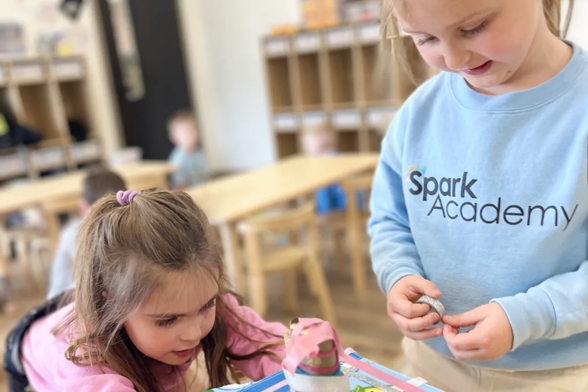 Two kindergarten students building a leprechaun trap together at Spark Academy — purposeful play in action