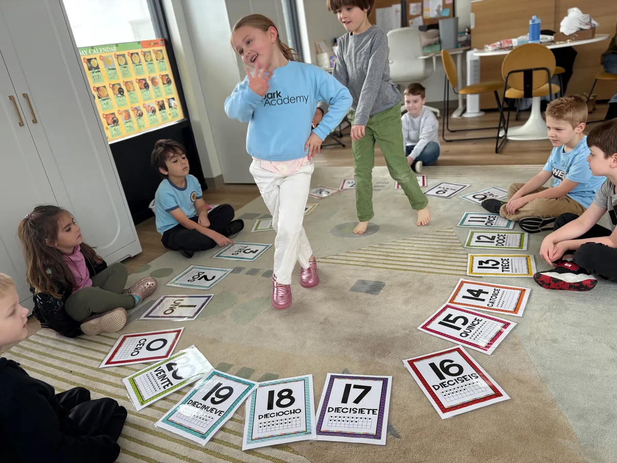 Children learning Spanish numbers through movement during Daily Enrichment at Spark Academy