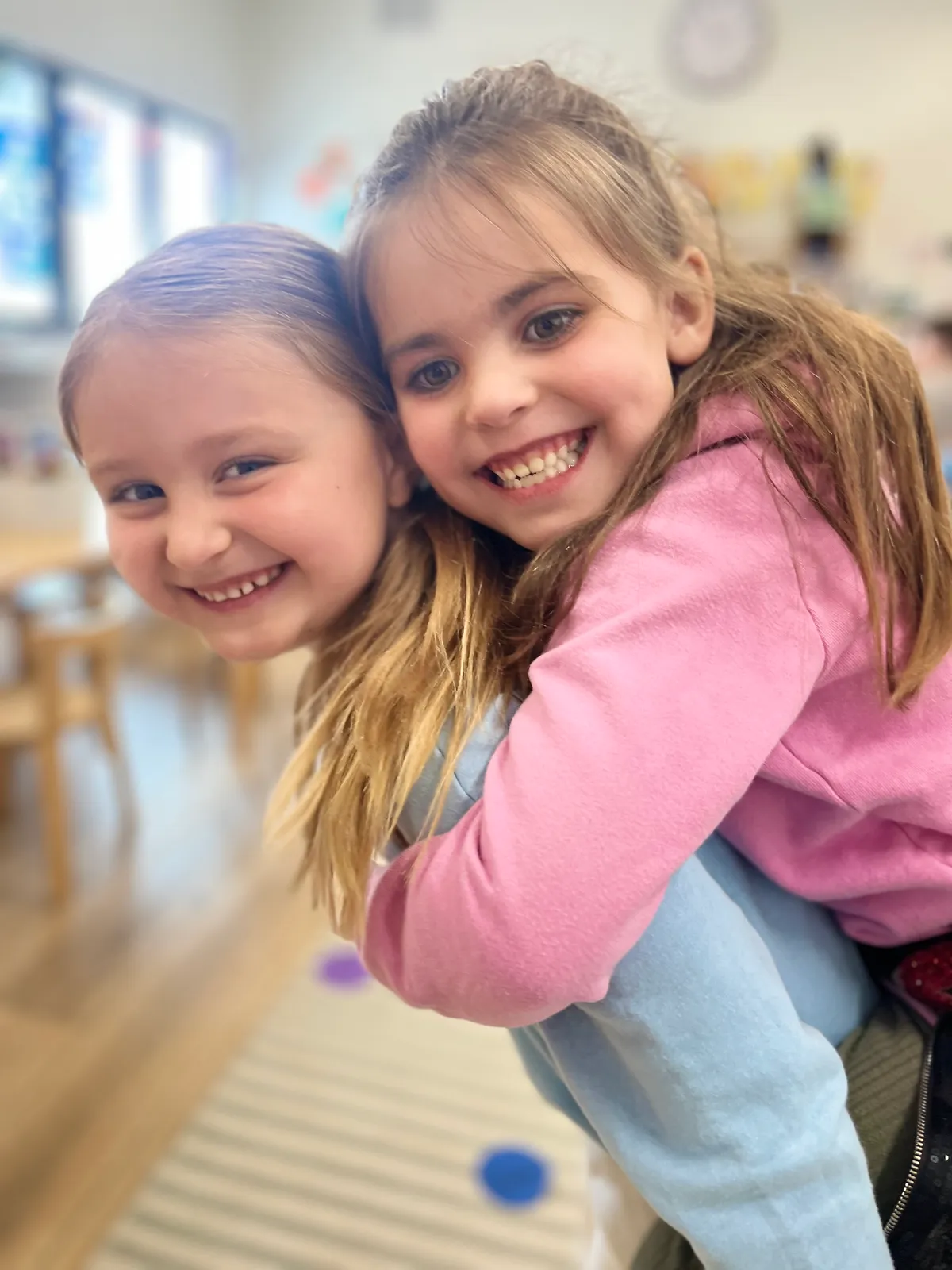 Two preschool friends sharing a joyful moment at Spark Academy
